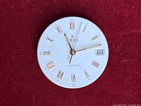 Front view of Ebel automatic watch movement with white dial, gold Roman markers, gold hands and date window