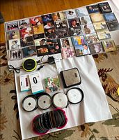 Full lot overview showing Fitbit box, CD player, adapter, CDs and cases