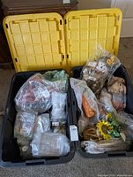 Two open black storage totes showing bubble-wrapped fall décor items