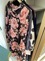 Floral rose print tunic with other tops on hangers