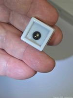 Close view of gemstone in gem box held between fingers