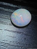 Top view of oval Ethiopian fire opal cabochon showing play of colour