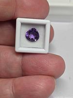 Front view of pear-cut amethyst in white display case