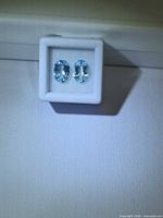 Pair of oval blue aquamarines in white gem box