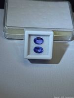 Two oval violet-blue tanzanites in small white display box