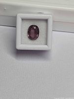 Front view of loose oval spinel in display case