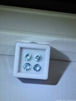 Four round sky-blue aquamarines in display box