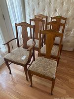 Six wooden dining chairs arranged, showing overall set
