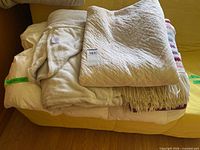 Stacked view: duvet, robe, quilt, woven throw with fringe