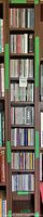 Tall dark-stained wooden shelving column filled with multiple rows of CDs, flanked by book shelves partially visible