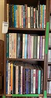 Entire bookcase showing three shelves of books and stacked CDs