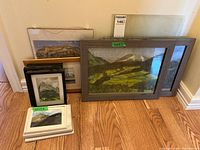 Group of framed and matted watercolour landscapes leaning against wall