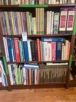 Wide view of three shelves filled with assorted gardening, herbal, and medical books
