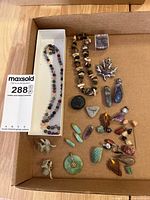 Full lot overview showing necklaces, pendants, loose stones in tray