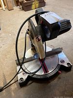 Overall view of mitre saw showing base, motor housing, power cord, blade guard