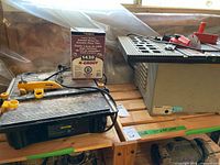 Both saws and grout box on shelf