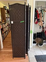 Folded dark woven wood three-panel room divider screens standing upright