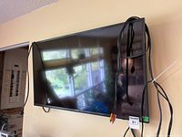 Front view of wall-mounted Samsung 40-inch TV with cables visible