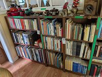 Front view of three brown pressboard bookcases filled with books
