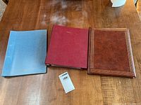 Blue, red and brown albums on table