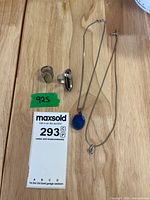 All four sterling silver pieces laid out: two rings, two necklaces