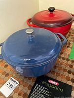 Blue and red enameled Dutch ovens with lids and Pyrex booklet