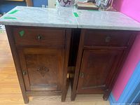 pair of wooden cabinets with marble tops front view