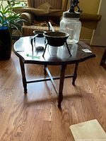 Full view of the octagonal wooden side table with turned legs and cross-stretcher