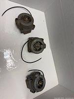 Three identical aluminum fuel/vacuum pumps displayed together