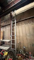Full view of aluminum straight ladder leaning against wall