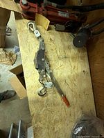 Full view of come-along winch on bench showing hooks, cable, lever