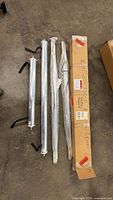 Four aluminum rollers on floor, two wrapped, two unwrapped