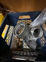 Crate with multiple cam-and-groove couplings and threaded adapters visible