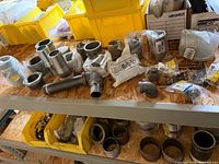 Overall lot on shelf with assorted galvanized and black iron fittings