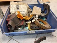 Blue bin containing pump housing, gaskets, bushings and packaging