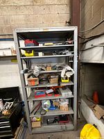 Full shelving view with assorted hand tools, hardware boxes and bins