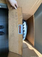 Cardboard box containing coiled black rubber strip