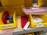 Bins containing red lens, bubble-wrapped lens, circuit board module