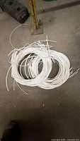 Two coils of white-insulated copper hookup wire on workshop floor