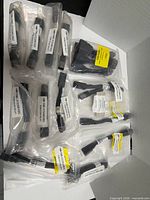 Multiple sealed bags of black plastic door relay switches with part labels visible