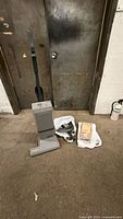 Full view of Electrolux upright vacuum with hose and replacement bags