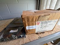 Closed cardboard box with Federal Signal label and anti-static bag beside it