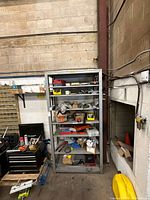 Front view of gray steel shelving unit with five shelves (contents to be removed)