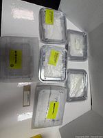 Six individually packaged silver plastic bezels visible inside box
