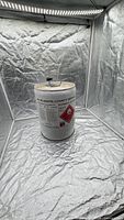 Front view of white metal drum showing flammable label and overall appearance