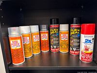 Eight aerosol cans on shelf showing brands and finishes