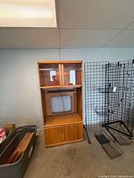 Front view of oak veneer entertainment center showing upper compartment, central TV opening, and lower cabinet