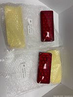 Pair of red LED tail lights in bubble wrap with labels