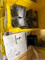 Five PAC Spreader Base Pockets in yellow bin, four sealed in plastic, one opened