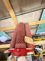 Red painted floating strainer with perforated intake and floats, showing patent number and brand stamp